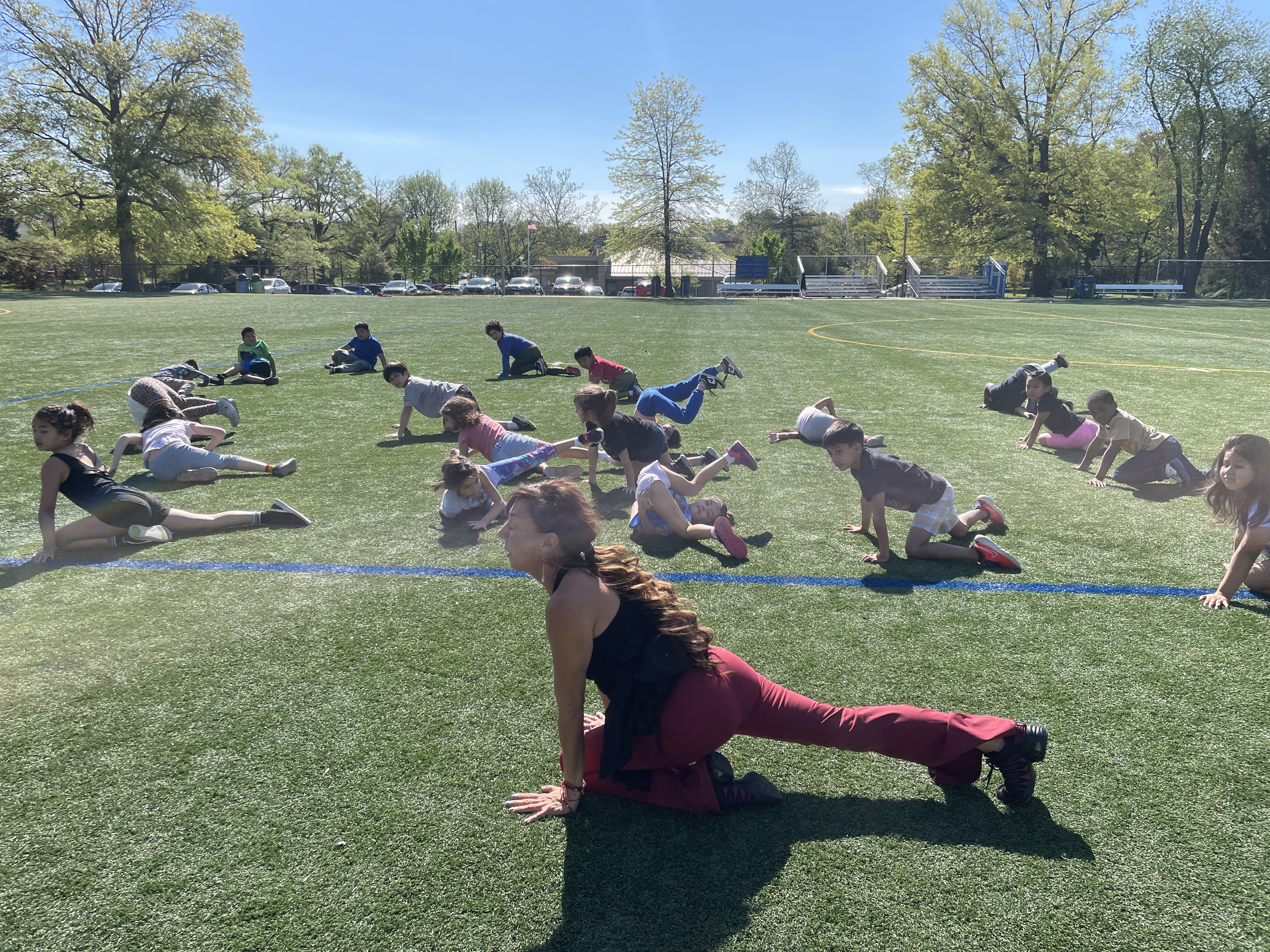 Ms. Cervantes, the Creative Movement teacher, working with 2nd graders outside. 